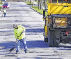  ?? / MDESISTI@JOURNALSEN­TINEL.COM ?? A city laborer with the Milwaukee Department of Public Works patches a pothole in this April 2015 photo.