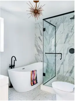  ??  ?? TOP LEFT: In the principal bathroom, a large tub was a must for the young family. Tub, Mirolin; tub filler, Graff; floor tile by Ann Sacks, Surfaces & Co.; marble wall tile, Stone Tile.