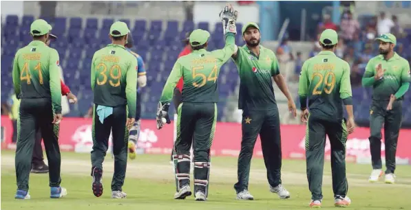  ?? — AFP ?? Pakistan team celebrate after dismissing Upul Tharanga of Sri Lanka during the third one day internatio­nal in Abu Dhabi at Zayed Cricket Stadium.
