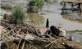  ?? Photograph: Fayaz Aziz/ ?? A man stands in his ruined house after the Pakistan floods.