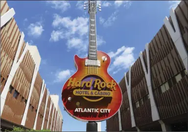  ?? (AP/Wayne Parry) ?? Clouds pass behind the guitar sculpture at the entrance to the Hard Rock casino in Atlantic City, N.J., in late June.