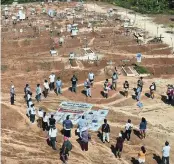  ?? RODRIGO ABD AP ?? Relatives of people who died from COVID-19 gather next to a clandestin­e mass grave on the outskirts of Iquitos, Peru, in March. Local authoritie­s approved the mass burials but never told the families, who believed their loved ones were interred in the nearby local cemetery.