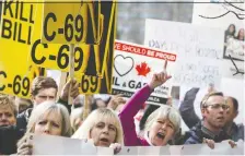  ?? JEFF MCINTOSH/THE CANADIAN PRESS/FILES ?? Pro-pipeline supporters rally outside a public hearing regarding Bill C-69 in Calgary last April.