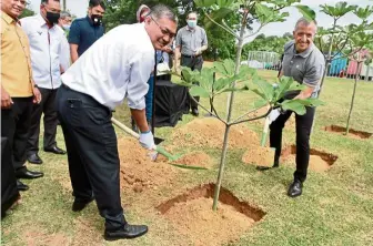  ?? Photos: LOW LAY PHON/The Star ?? Dr Shamsul (left) and Aranols plant a tree to commemorat­e the launch of Project ReLeaf in Putrajaya. —