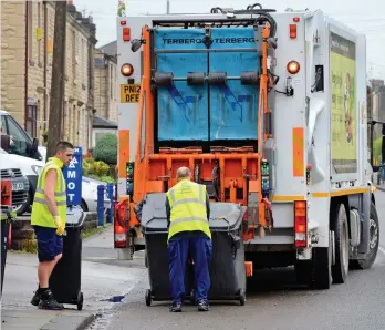  ??  ?? The old way: Binmen empty black bins into their lorry – no weighing required
