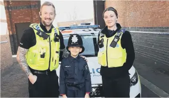  ?? ?? Riley with two officers during his visit to Millbank Police Station.