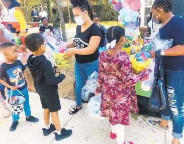  ?? DONOVAN CONAWAY/CAPITAL GAZETTE PHOTOS ?? Asia Williams hands out Easter baskets to kids Sunday on Clay Street in Annapolis. The event was part of an effort to foster a greater sense of community.