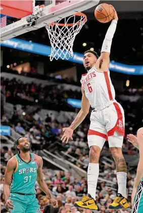  ?? Darren Abate/Associated Press ?? The Rockets’ KJ Martin dunks for two of his 14 points as the Spurs’ Keita Bates-Diop looks on during the first half of Saturday’s game in San Antonio.