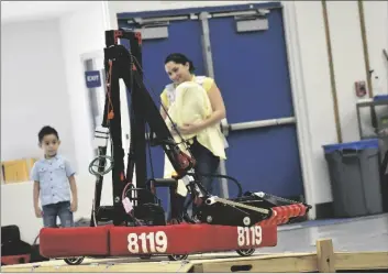  ?? PHOTO SHARON BURNS ?? A parent and child watch as Imperial’s robot balances on a wooden platform during the Central and Imperial robotics clubs’ practice session on Saturday, March 18, in El Centro.