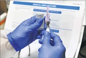  ?? ASSOCIATED PRESS FILE PHOTO ?? Nurse Kathe Olmstead prepares a shot that is part of a possible COVID-19vaccine, developed by the National Institutes of Health and Moderna Inc., in Binghamton, N.Y.