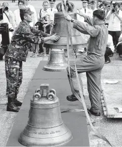  ?? Bullit Marquez / Associated Press ?? Philippine Air Force personnel on Tuesday unload three church bells seized by U.S. troops as war trophies more than a century ago. The bells are revered by Filipinos as symbols of national pride.