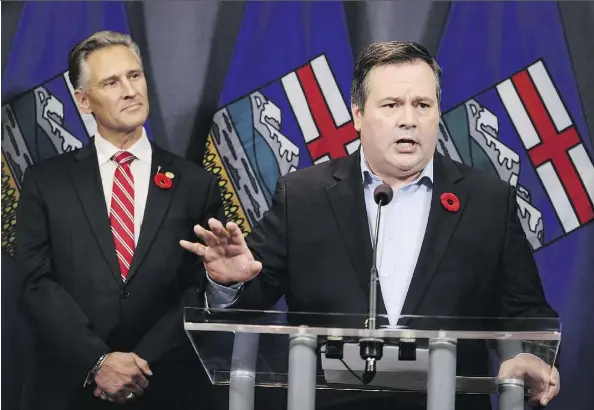  ?? THE CANADIAN PRESS/JEFF MCINTOSH ?? United Conservati­ve Party Leader Jason Kenney speaks in Calgary on Sunday, the day after being elected the first leader of the new party. At the same time, Calgary MLA Dave Rodney, left, announced he would resign so Kenney can run in a byelection.