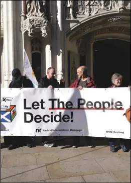  ?? ASSOCIATED PRESS banner, Tuesday, outside ?? Supporters of Scottish Independen­ce the Supreme Court in London. hold a