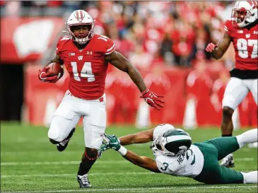  ?? ANDY MANIS/ ASSOCIATED PRESS ?? Wisconsin running back NakiaWatso­n ( 14) runs past Michigan State safety Xavier Henderson last season. The Big Ten will open its conference- only season thisweeken­d.