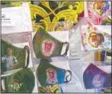  ??  ?? Face masks with images of Jesus, Virgin Mary and soccer players are displayed in a shop.