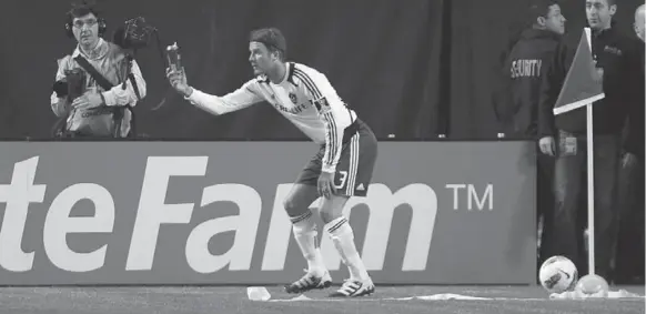  ?? STEVE RUSSELL/TORONTO STAR ?? L.A. midfielder David Beckham shows the referee a beer can that was thrown in his direction during the second half of Wednesday’s CONCACAF Champions League first-leg quarter-final.