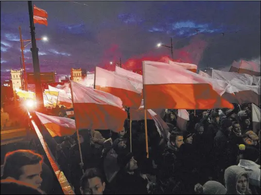  ?? Czarek Sokolowski The Associated Press ?? Demonstrat­ors burn flares and wave Polish flags on Saturday during the annual march to commemorat­e Poland’s independen­ce day in Warsaw, Poland.