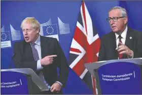  ?? AP/FRANCISCO SECO ?? British Prime Minister Boris Johnson (left) and European Commission President Jean-Claude Juncker make prepared statements Thursday during a press conference at EU headquarte­rs in Brussels. Britain and the European Union reached a new tentative Brexit deal on Thursday, hoping to finally escape the acrimony, divisions and frustratio­n of their three-year divorce battle.