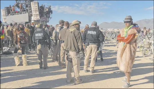  ?? Andy Barron The Associated Press file ?? In this 2015 photo, officers keep an eye on Burning Man participan­ts. Organizers of the festival vowed to fight any requiremen­t to hire a private security company for the screening of vehicles, participan­ts, vendors, contractor­s, staff and volunteers.