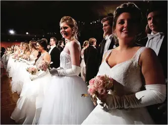  ??  ?? Debutantes and their escorts line up before a waltz begins at the Internatio­nal Debutante Ball in New York.