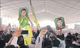  ?? HT PHOTO ?? Supporters of INLD MP Dushyant Chautala raising his portraits and party youth wing’s flags during the speech of senior party leader Abhay Chautala at a rally at Gohana in Sonepat district.