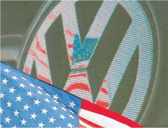  ?? FOTO: DPA ?? Die US- amerikanis­che Flagge in Chattanoog­a vor einem VW- Logo. Der Autokonzer­n wird den Rückkauf eines großen Teils seiner in den USA knapp 600 000 manipulier­ten Diesel anbieten müssen.