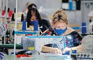  ?? SUSAN STOCKER/SUN SENTINEL PHOTOS ?? Marta Morta, a seamstress with Lacrossewe­ar in Coconut Creek, sews masks for the COVID-19 virus, as the company reconfigur­es its production line from sports apparel to protective equipment.