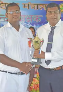  ?? Photo: Shratika Naidu ?? Hindi poster competitio­n third prize getter in the secondary division Shahil Ram of Labasa Sangam College receives his trophy from Minister for Education, Heritage and Arts Mahendra Reddy on May 17, 2017.