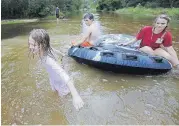  ?? [AP PHOTO] ?? Crimson Peters, 7, left, Tracy Neilsen, 13, center, and Macee Nelson, 15, ride in an inner tube down a flooded street after Hurricane Nate on Sunday in Coden, Ala.