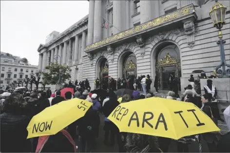  ?? JEFF CHIU/AP ?? A CROWD LISTENS TO SPEAKERS AT A REPARATION­S RALLY outside of City Hall in San Francisco on Tuesday. Supervisor­s in San Francisco are taking up a draft reparation­s proposal that includes a $5 million lump-sum payment for every eligible Black person.