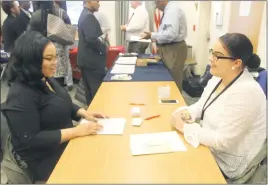  ?? STAFF PHOTOS BY TIFFANY WATSON ?? Waldorf resident Katrice Warren, 22, discusses the applicatio­n process with Danielle Mothershea­d, a manager at Fashion To Figure in St. Charles Towne Center, during the Young Adult Job Fair on March 22.