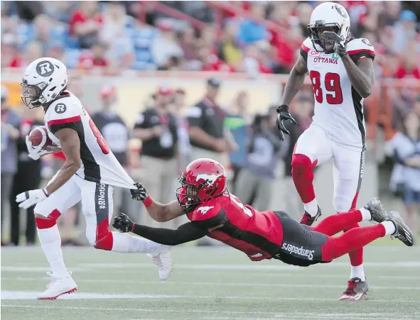  ?? — THE CANADIAN PRESS FILES ?? While it was Calgary Stampeders defender Ciante Evans holding on for dear life against Ottawa’s Diontae Spencer on the field earlier this year, it’s East Division teams like the Redblacks who are being left in the West Division’s proverbial dust.