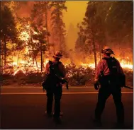  ?? (AP/Marcio Jose Sanchez) ?? Firefighte­rs keep an eye on the Creek Fire Sunday along California Highway 168 in Shaver Lake, Calif.