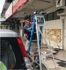  ??  ?? Photo shows one of the two men doing renovation works on a building, who was fined RM1,000 for not wearing a face mask in a public area.