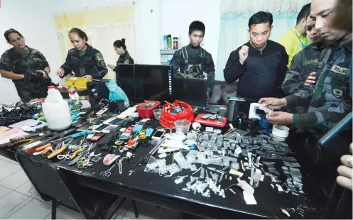  ?? SUNSTAR FOTO / AMPER CAMPAÑA ?? ILLEGAL ITEMS. The team that conducted the greyhound operation sorts through the items seized from inmates at the Cebu Provincial Detention and Rehabilita­tion Center.