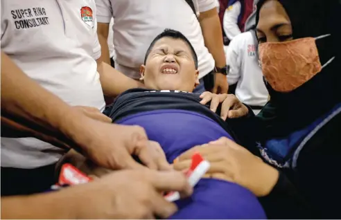  ?? DIPTA WAHYU/JAWA POS ?? PESERTA JUGA DISKRINING: Salah seorang bocah menahan rasa sakit saat dikhitan kemarin. Kegiatan tersebut digagas Persatuan Srikandi Sunat Indonesia.