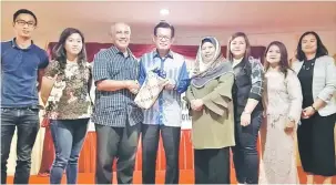  ??  ?? TERIMA KASIH: Lee (empat kiri) menerima cenderamat­a daripada Dr Faizul (tiga kiri) sambil disaksikan anggota PPKK, PKKK dan PAKK Bahagian Miri.