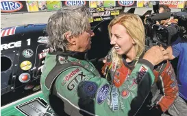  ?? JOSE CARLOS FAJARDO/STAFF ?? John Force, left, congratula­tes daughter and fellow Funny Car driver Courtney Force, right, after the two raced each other at NHRA Sonoma Nationals in 2014. Courtney placed first.
