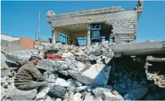  ??  ?? Ein Iraker sitzt vor seinem durch einen Bombenangr­iff zerstörten Haus im umkämpf ten Stadtteil al Dschadida in West Mossul.