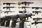  ?? Seth Perlman / Associated Press ?? Assault weapons and hand guns are seen for sale at Capitol City Arms Supply in Springfiel­d, Ill.