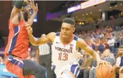  ?? YAN M. KELLY/GETTY IMAGES ?? Virginia’s Casey Morsell drives past Stony Brook’s Elijah Olaniyi during a Dec. 18 game in Charlottes­ville.