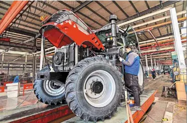  ?? — AFP ?? Growth strategy: an employee works on a tractor production line at a factory in Weifang. This year’s Government Work report underlined that china will strive to modernise its industrial system and develop new quality productive forces at a faster pace.