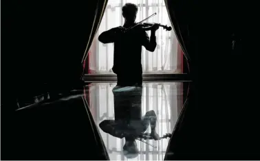  ?? BILD: SN/AFP/ DANIEL LEAL-OLIVAS ?? Welche Melodien sind einer Geige zu entlocken? Diese Frage macht junge Komponiste­n ratlos.