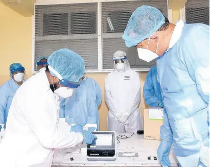  ?? CONTRIBUTE­D ?? Minister of Health and Wellness Dr Christophe­r Tufton (right) is briefed on the function of the F200 machine, which is used to detect coronaviru­s (COVID-19) infections under the antigen testing procedure, by medical technologi­st at the National Public Health Laboratory, Sheamar Wiles. Occasion was a demonstrat­ion at the Spanish Town Hospital in St Catherine on Wednesday, which is among nine sites where antigen testing is being piloted.