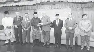  ?? ?? TERIMALAH: Awang Tengah menyerahka­n sumbangan derma tahunan PUSAKA kepada wakil penerima sambil disaksikan Zainal Abidin (tiga kiri), Naroden (tiga kanan) serta Hashim (dua kanan) pada majlis tersebut.