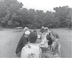  ?? PROVIDED ?? Wearing masks as a precaution, the Rt. Rev. Poulson Reed, bishop of the Episcopal Diocese of Oklahoma, top center, and youth campers chat at St. Crispin’s Conference Center and Camp in Wewoka, where camp leaders said there were no COVID outbreaks during this summer’s camping season.