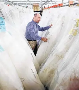  ?? CARLINE JEAN/STAFF PHOTOGRAPH­ER ?? Auctioneer Stan Crooks gets ready for the auction of Alfred Angelo dresses and other warehouse inventory on Saturday in Deerfield Beach.