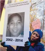  ?? JOSE LUIS MAGANA/THE ASSOCIATED PRESS ?? Tomiko Shine holds up a picture of Tamir Rice, the 12-year-old boy fatally shot by a rookie police officer in Cleveland on Nov. 22, 2014, during a protest on Dec. 1, 2014.