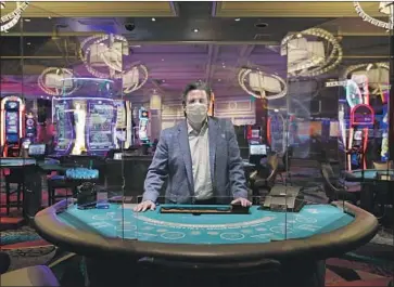  ?? John Locher Associated Press ?? MGM acting CEO Bill Hornbuckle at a Bellagio table with protective barriers. Vegas casinos open next week.