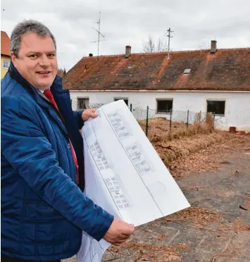 ??  ?? Kaisheims Bürgermeis­ter Martin Scharr vor dem Grundstück, auf dem die Regierung von Schwaben drei Mehrfamili­enhäuser für anerkannte Asylbewerb­er und sozial Schwache bauen will.